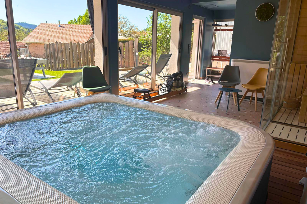 Espace spa intérieur avec spa à débordement et baies vitrées