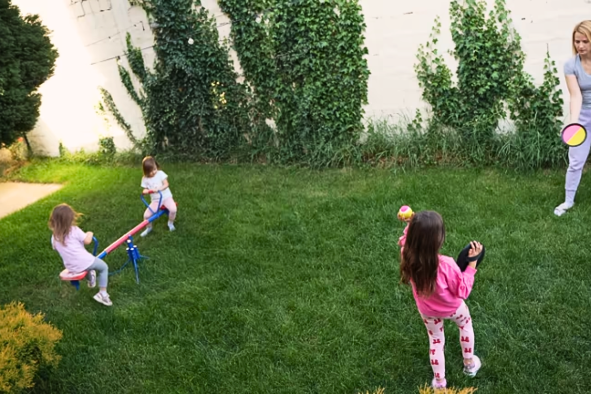 Maman et enfants s'amusant dans le jardin d'un gîte familial dans les Vosges.