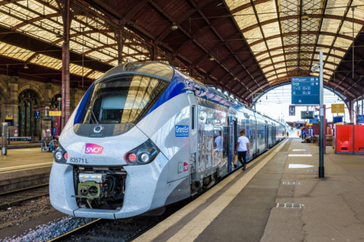 trajet en train Strasbourg Bruyères gîte, une gare pittoresque entourée de végétation.