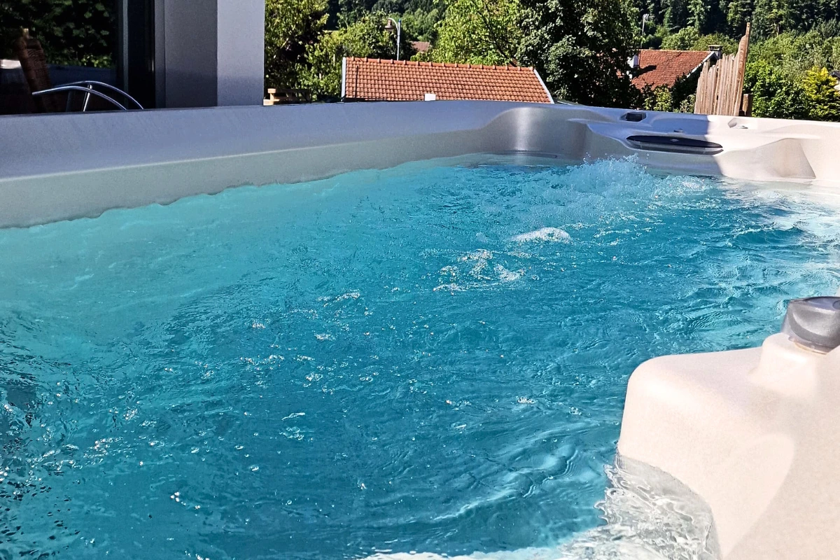 Piscine chauffée avec jacuzzi dans un gîte de luxe pour les familles.