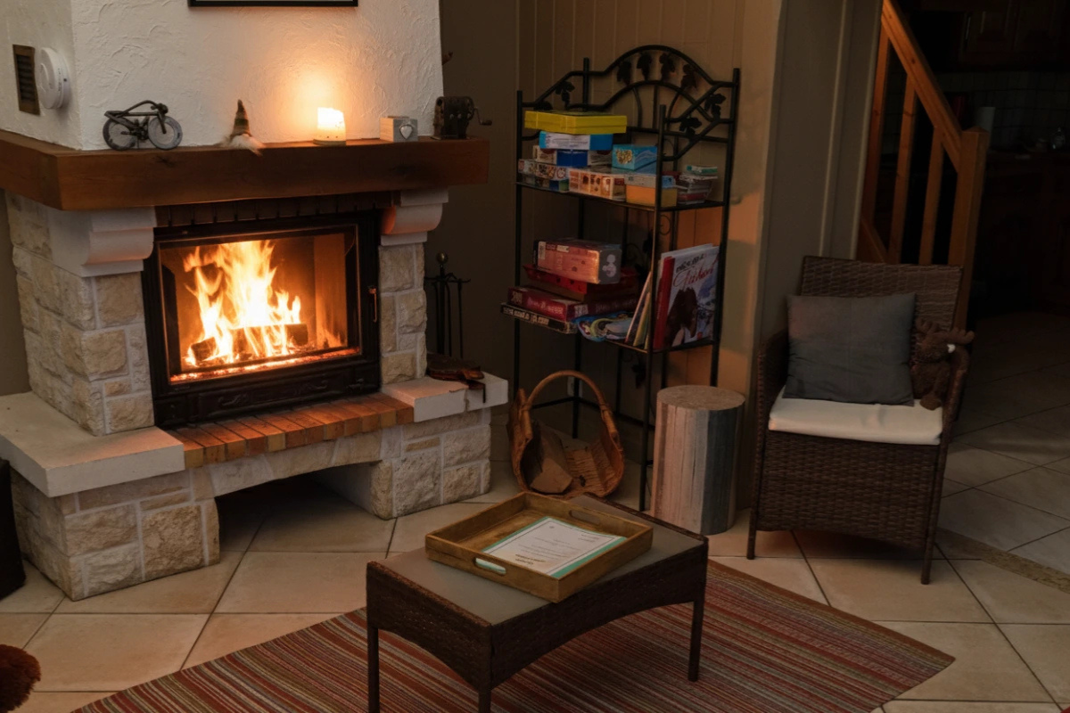 Intérieur du gîte Le Chalet du Domaine de la Répandise avec cheminée allumée, symbolisant le confort cocooning et la tranquillité après la neige.