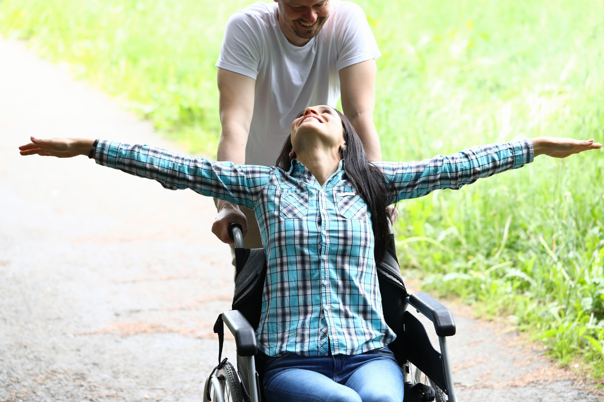 Personne en situation de handicap se promenant sur un sentier forestier aménagé et plat dans les Vosges.